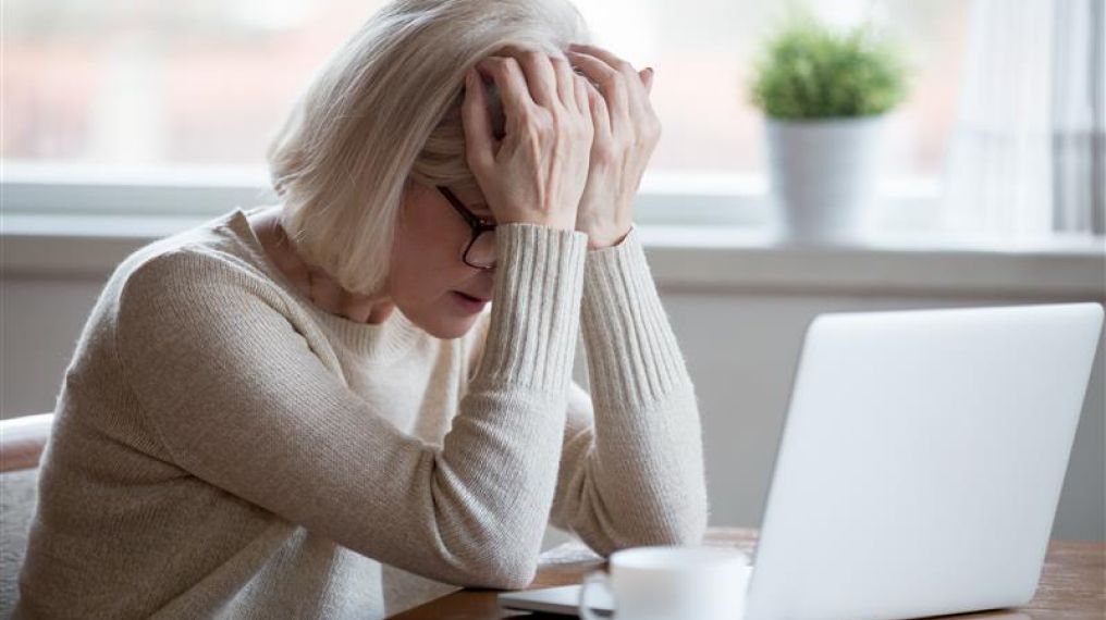 Image of an apprehensive person sitting by their work computer