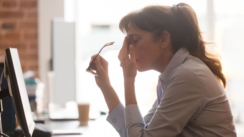 Image of an apprehensive person sitting by their work computer